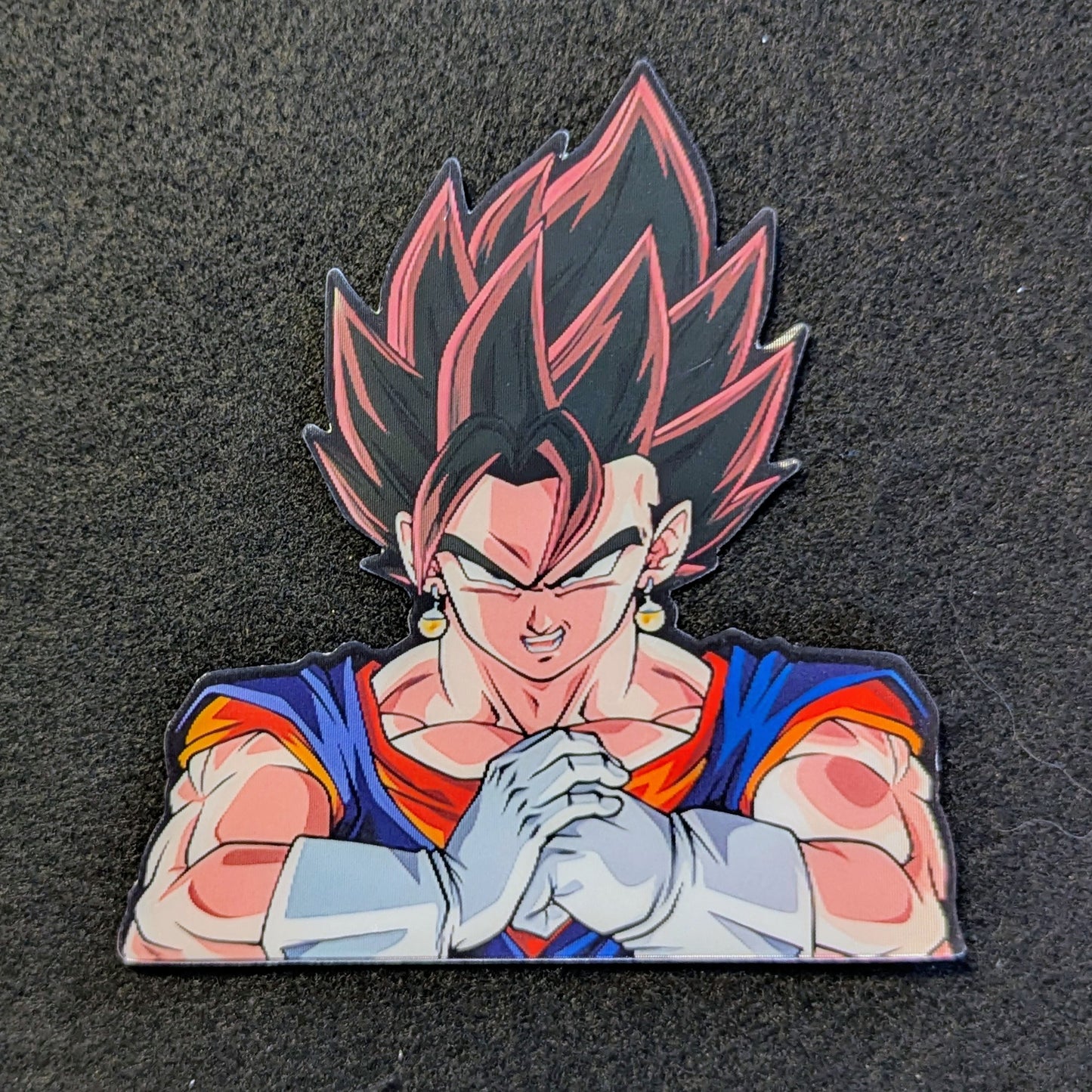 Character with dark hair and red and blue outfit Vegito cracking his knuckles on a black background