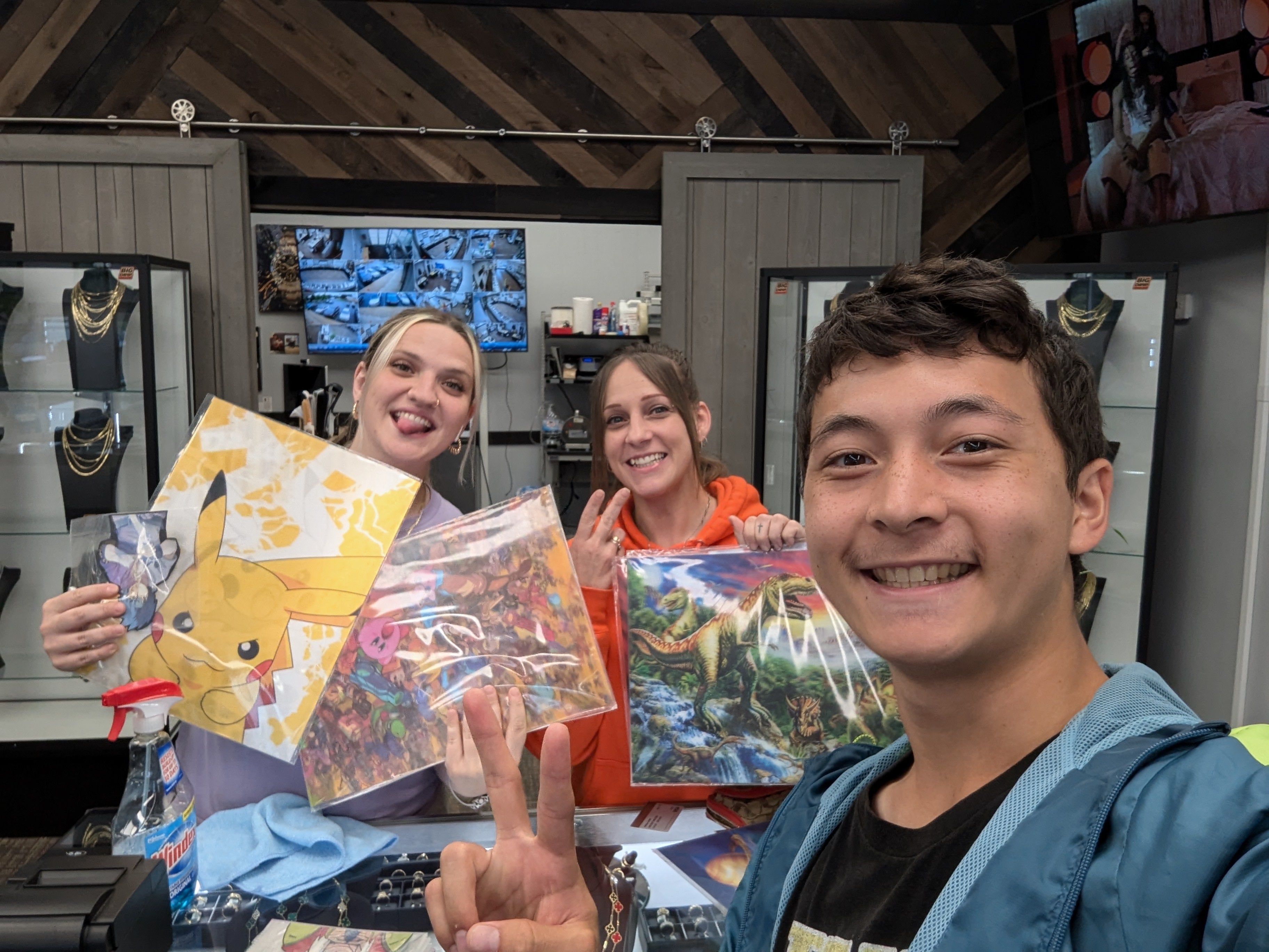 Three people holding colorful 3D posters in a store setting