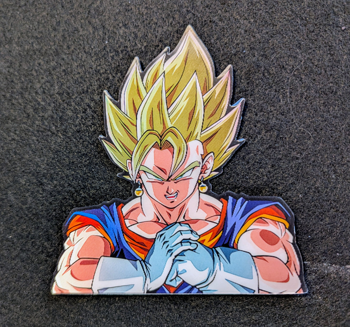 Character with yellow hair and red and blue outfit Vegito cracking his knuckles on a black background