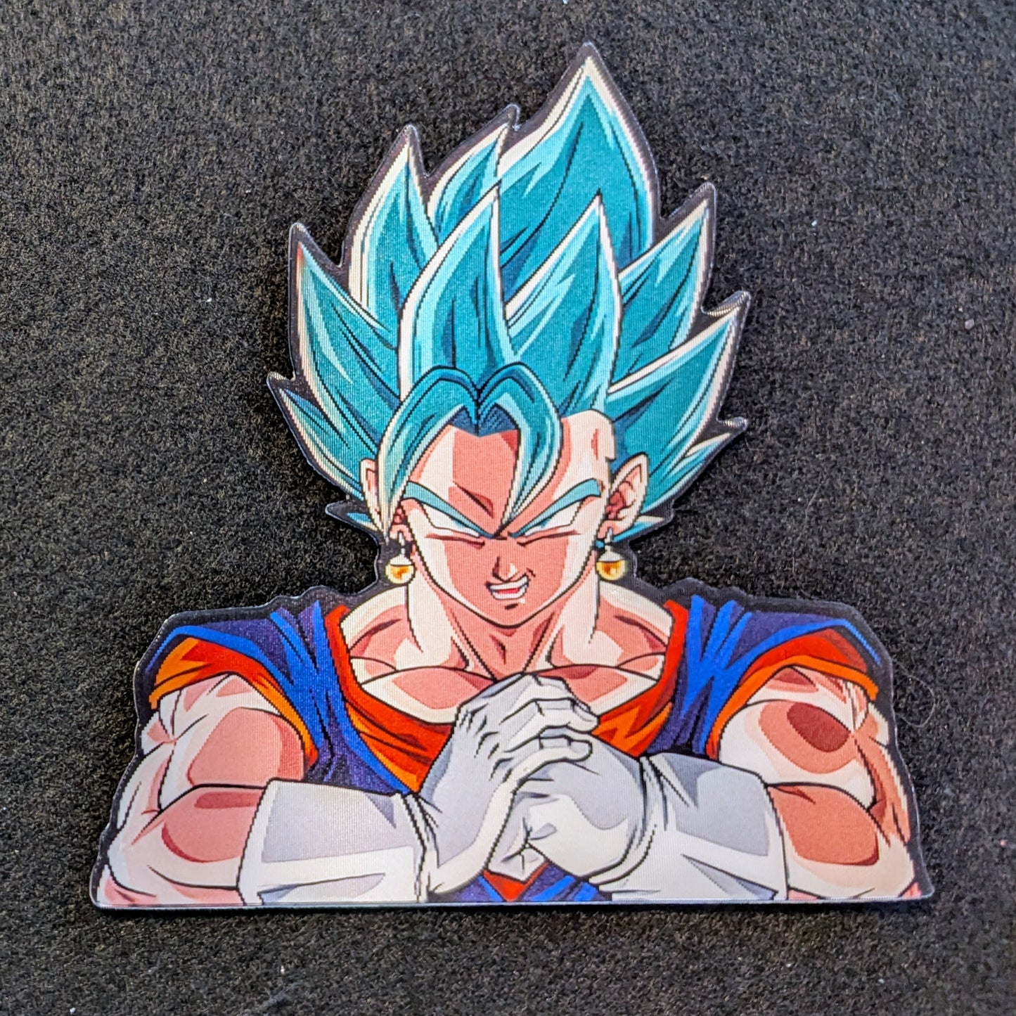 Character with blue hair and red and blue outfit Vegito cracking his knuckles on a black background