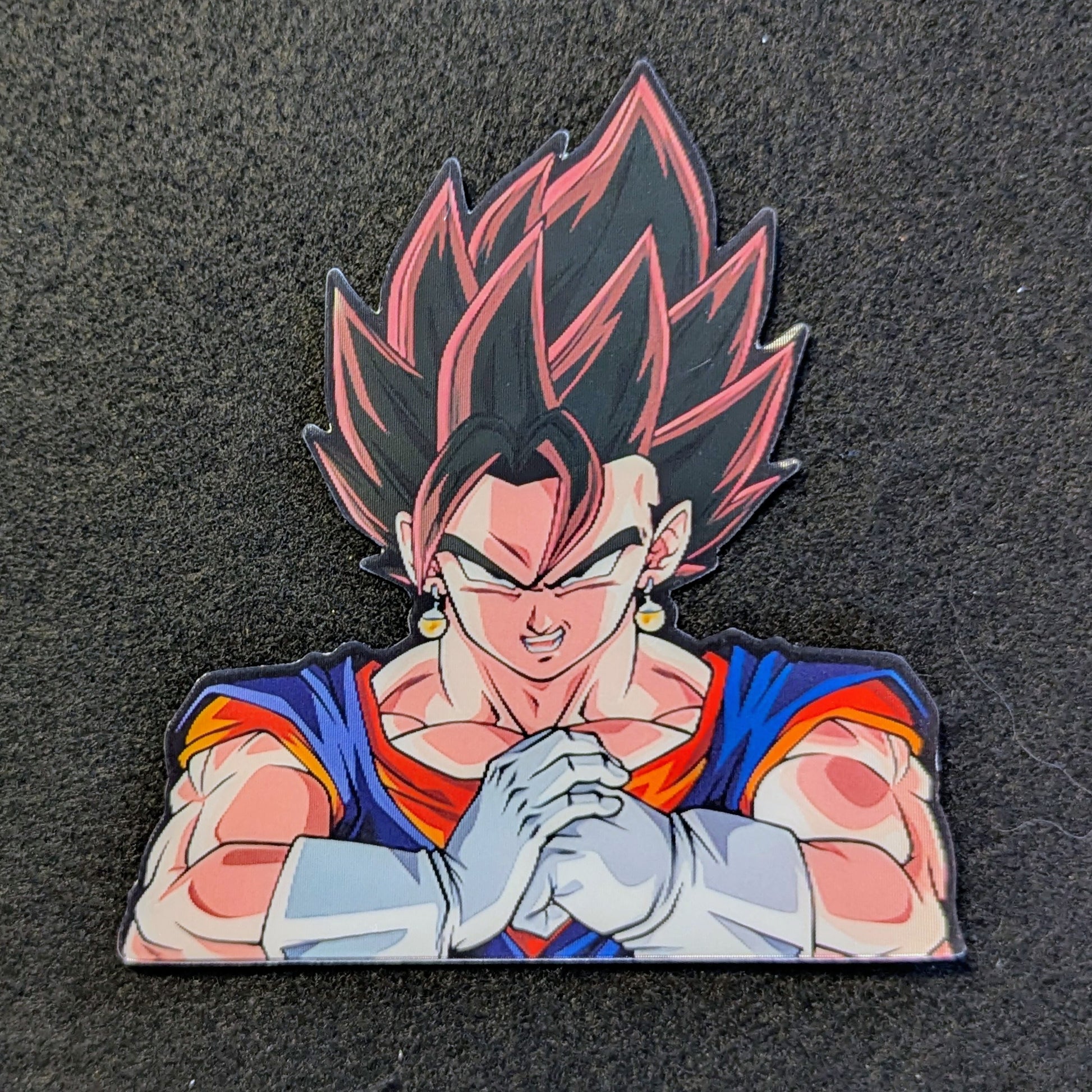 Character with dark hair and red and blue outfit Vegito cracking his knuckles on a black background
